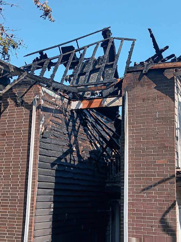 Charred upper structure of a residential building post-fire