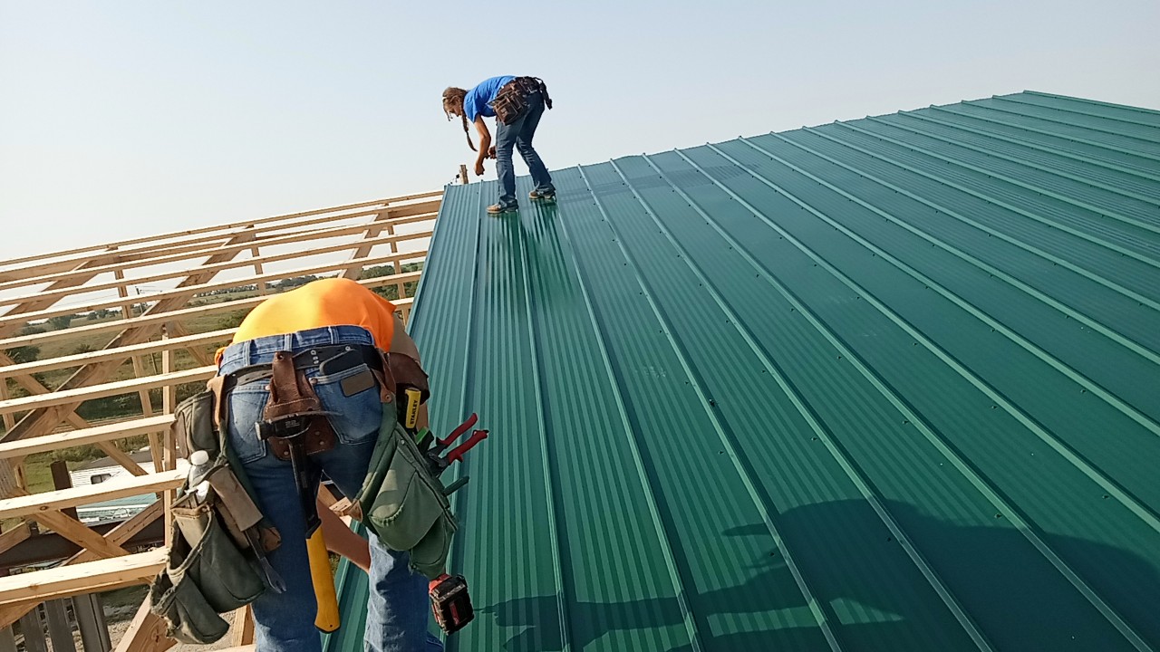Two Binnacle contractors installing a metal roof on a job site